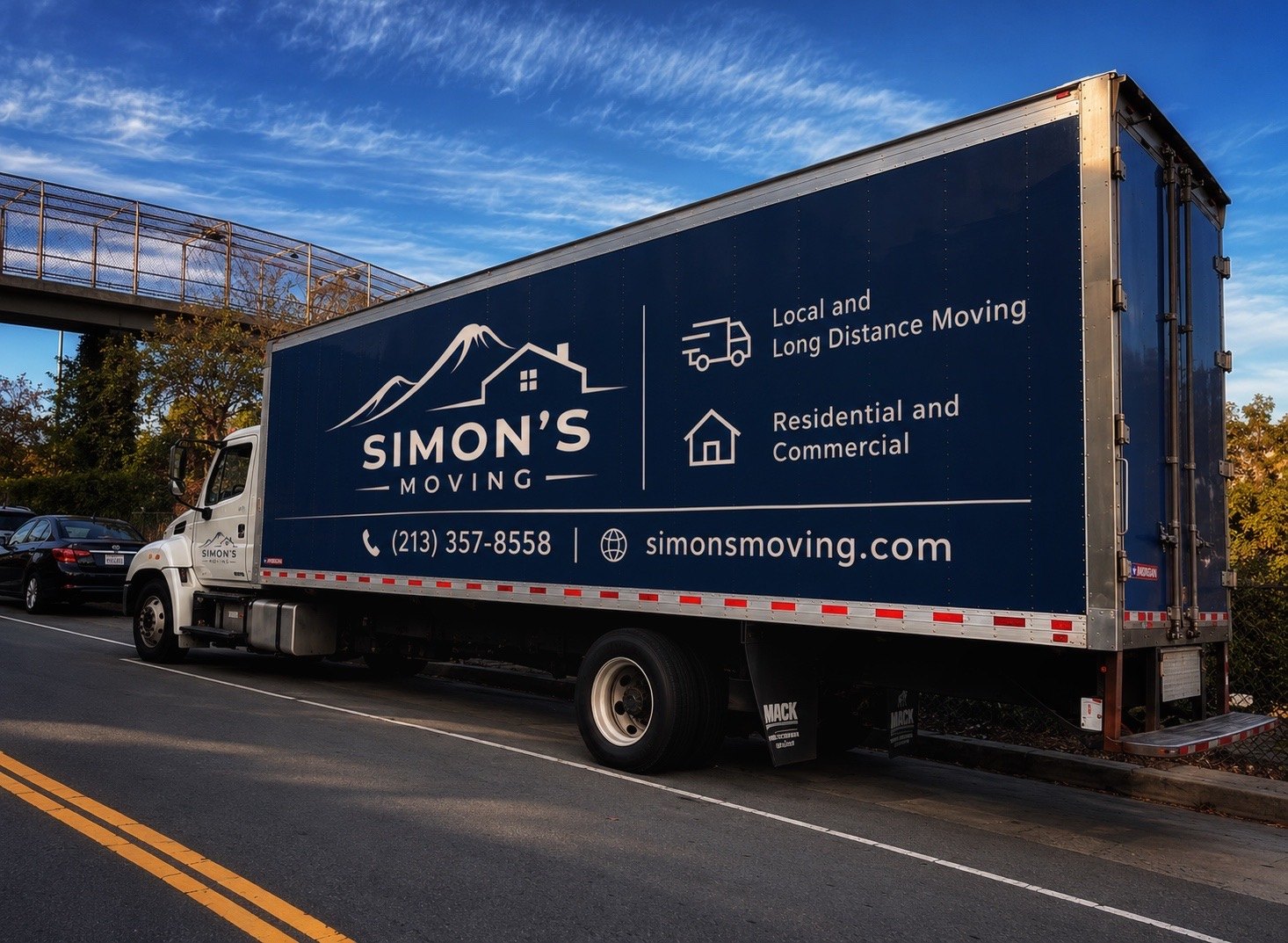 Simon's Moving navy-branded truck photographed from a rear side angle